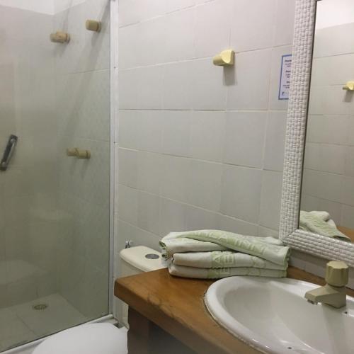 a bathroom with a sink and a shower and a toilet at Barla Inn Suites in Búzios