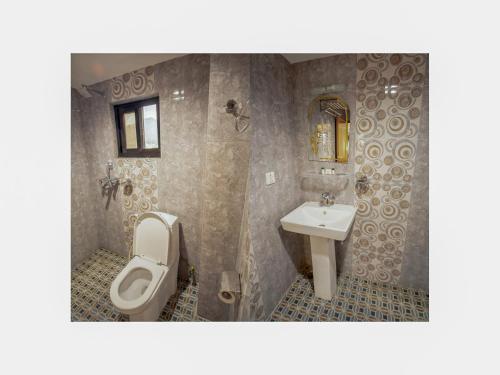 a bathroom with a toilet and a sink at Hotel River Park in Pokhara