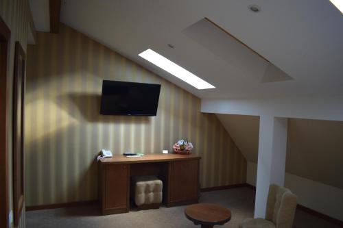 a room with a table and a tv on the wall at Hotel Gott in Braşov