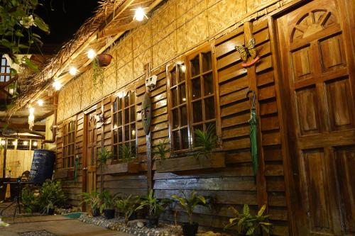 a wooden wall with windows and plants on it at Natura Vista in Panglao