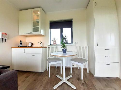 una pequeña cocina con mesa y 2 sillas en Austurey Cottages, en Laugarvatn
