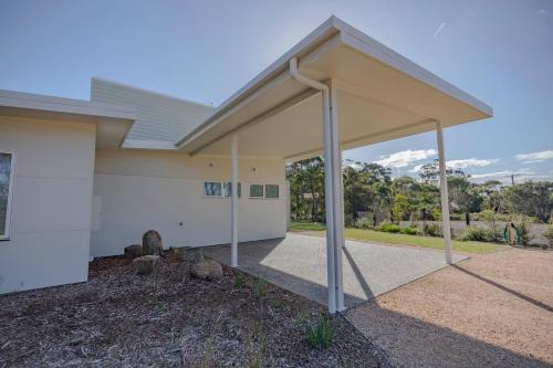 a building with awning on the side of it at Baileys Beach House in Binalong Bay