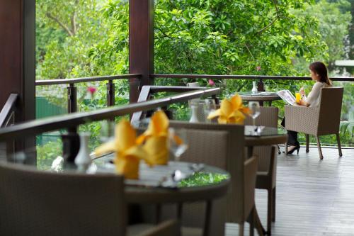 a woman sitting at a table reading a book at Fraser Suites Hanoi in Hanoi