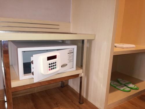 a microwave on a shelf in a room at Zest Jemursari by Swiss-Belhotel International in Surabaya