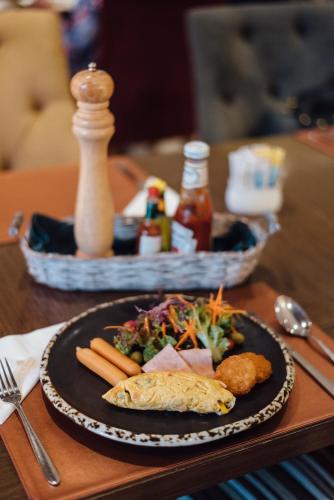 a plate of food sitting on a wooden table at Al Meroz Hotel Bangkok - The Leading Halal Hotel in Bangkok