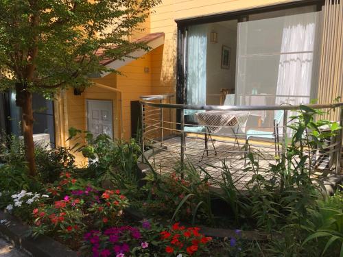 a patio with flowers and a table and chairs at 伊道荘園 in Futo