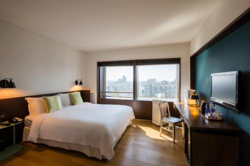 a hotel room with a bed and a desk and a television at Beijing New World Centre Tongpai Hotel in Beijing