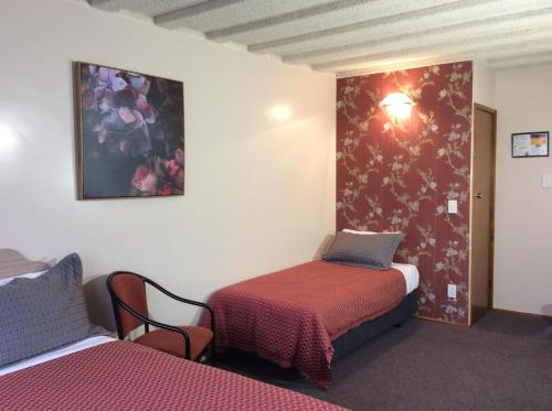 a room with two beds and a wall with flowers at AAA Marlin Motel in Picton