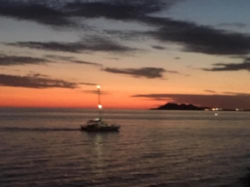 a small boat in the ocean at sunset at DOLPHIN Maeva Residencial in Puerto Peñasco