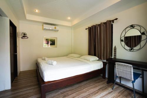 a small bedroom with a bed and a mirror at Bayview Resort in Ban Chak Phai