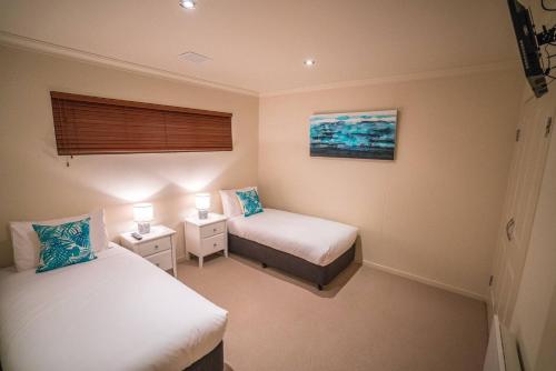 ein kleines Zimmer mit 2 Betten und einem Fenster in der Unterkunft Villa Jasper Bay of Fires in Binalong Bay