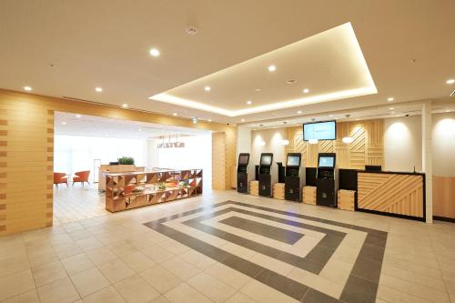eine Lobby mit einer Reihe von Kassierern in einem Gebäude in der Unterkunft Sotetsu Fresa Inn Osaka Namba in Osaka