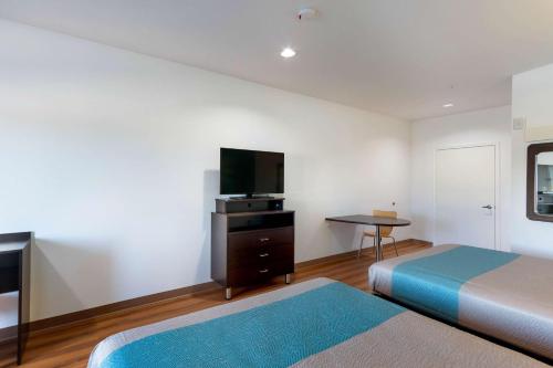 a hotel room with two beds and a flat screen tv at Motel 6-Channelview, TX in Channelview