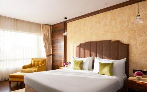 a hotel room with a large bed and a chair at President - IHCL SeleQtions in Mumbai