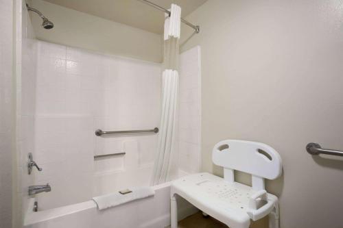 a white bathroom with a toilet and a shower at Howard Johnson by Wyndham Buena Park in Buena Park