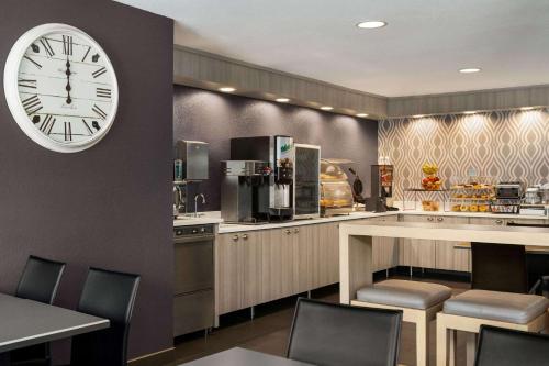 a restaurant with a large clock on a wall at Microtel Inn and Suites - Inver Grove Heights in Inver Grove Heights