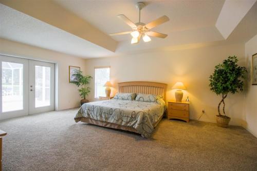 a bedroom with a bed and a ceiling fan at Luxury 4BR Pool Home with Jacuzzi- Inverness in Inverness