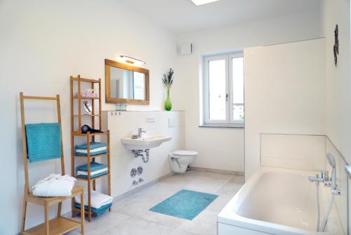 ein Badezimmer mit einer Badewanne, einem Waschbecken und einem WC in der Unterkunft Ferienwohnung Bergmaier in Bad Birnbach