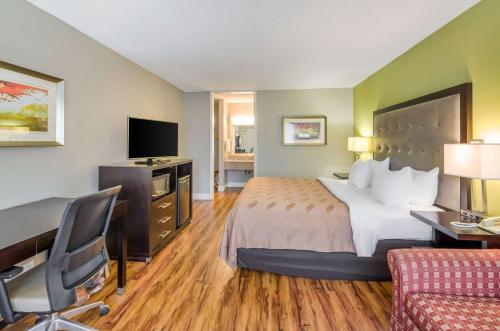a hotel room with a bed and a tv at Quality Inn Roanoke Airport in Roanoke