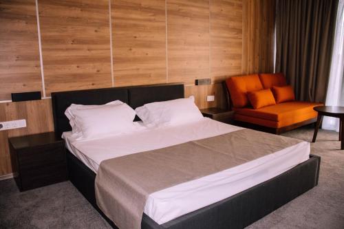 a bedroom with a large bed and a chair at Hotel Nobilis Hall in K'obulet'i