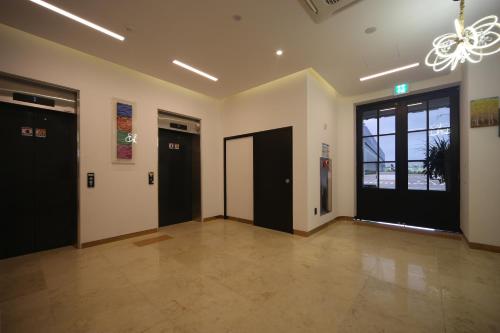 a large room with two doors and a chandelier at Bestie Hotel in Busan