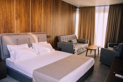 a hotel room with a bed and two chairs at Hotel Nobilis Hall in K'obulet'i