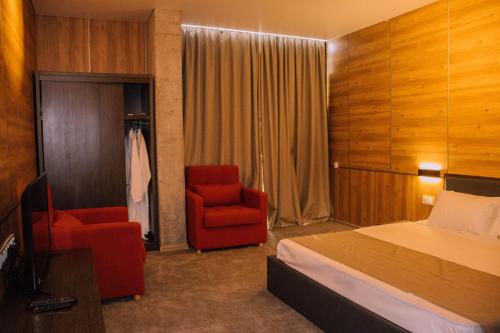 a hotel room with a bed and two chairs at Hotel Nobilis Hall in K'obulet'i