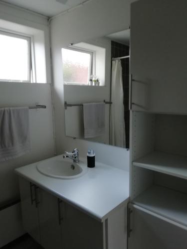 a white bathroom with a sink and a mirror at Like home Holiday House 9 A in Varde