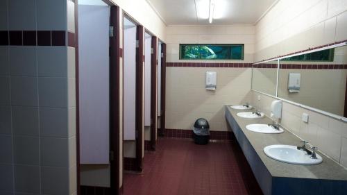 uma casa de banho com três lavatórios e uma fila de espelhos em Daintree Crocodylus em Cow Bay
