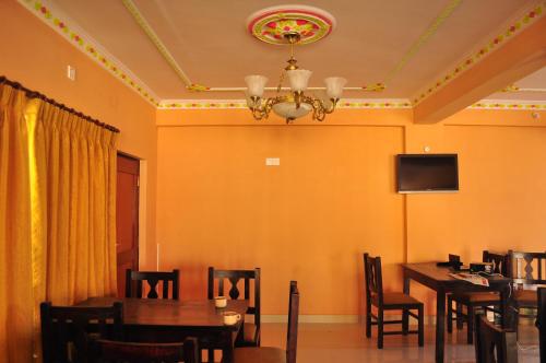 a dining room with tables and chairs and a chandelier at Hotel Valley View Inn in Nagarkot