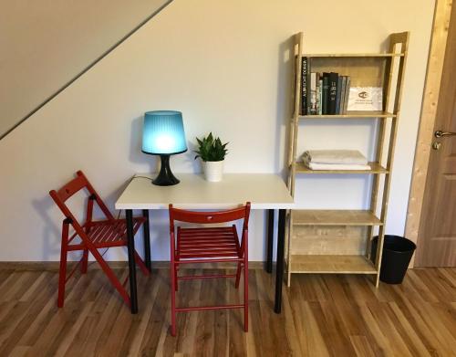 a table with two chairs and a lamp on it at Room in a Scandinavian Style House in Vilnius