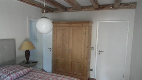 a bedroom with a bed and a wooden cabinet at Hotel Café del Maar in Schalkenmehren