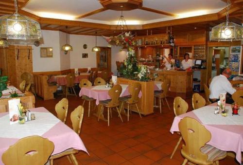 a restaurant with tables and chairs and people in the kitchen at Landgasthof im Ehegrund in Sugenheim