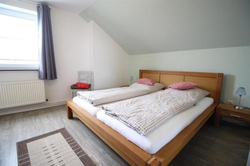 a bedroom with two beds and a large window at Ferienhof-Friedenshof-Gerste in Vollerwiek