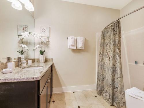 a bathroom with a shower curtain and a sink at Modern Condos near French Quarter & Bourbon Street in New Orleans