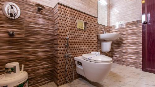 a bathroom with a toilet and a sink at Woodside residency in Thekkady