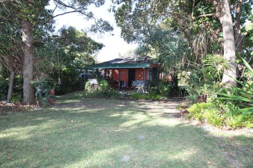 a house in the middle of a yard with trees at Signal Cottage in Cowan Cowan