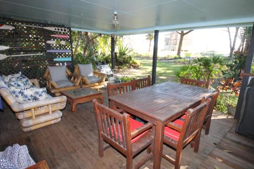 a patio with a wooden table and chairs and wine racks at Signal Cottage in Cowan Cowan