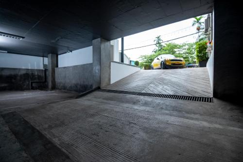 an empty parking garage with a yellow car in the background at S 2 Modern Boutique Hotel in Vientiane