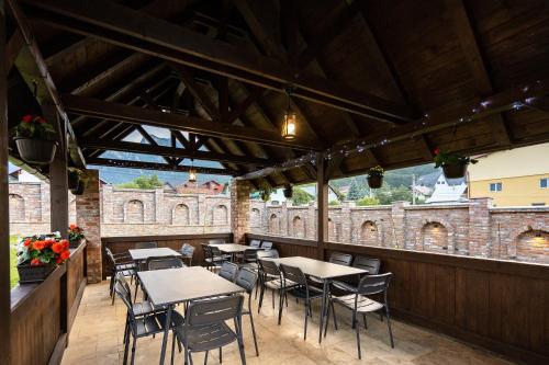 a restaurant with tables and chairs on a patio at VILA NORBE in Buşteni