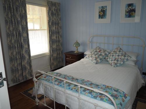 a bedroom with a bed and a window at Cobblers Cottage B&B in Willunga