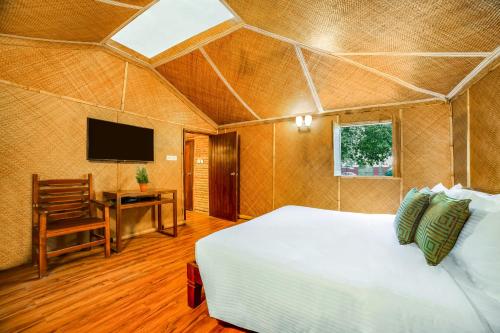 1 dormitorio con 1 cama, escritorio y TV en Lemon Tree Wildlife Resort, Bandhavgarh, en Tāla