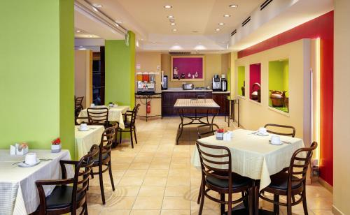 a restaurant with tables and chairs and a kitchen at Mizpe Yam Boutique Hotel in Netanya