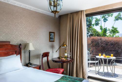 Cette chambre d'hôtel comprend un lit et une terrasse avec une table. dans l'établissement Europa 1917, à Tibériade