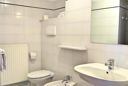 uma casa de banho branca com um lavatório e um WC em Casa Sandra Bertolini em Nago-Torbole