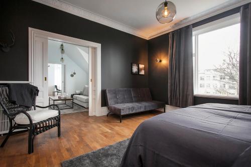 レイキャビクにあるSudurgata - Luxury Dream Apartmentのベッドルーム1室(ベッド1台、椅子、ソファ付)