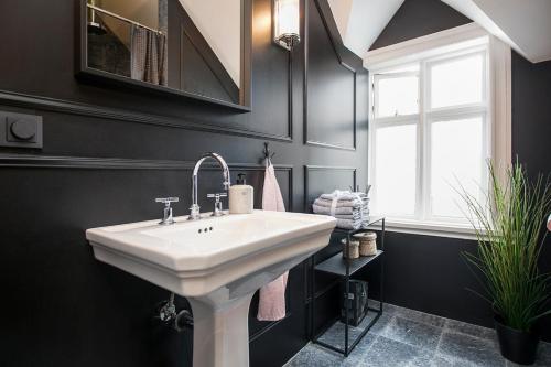 a bathroom with a white sink and a window at Sudurgata - Luxury Dream Apartment in Reykjavík