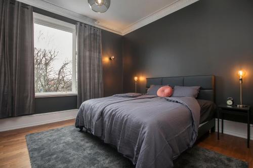 a bedroom with a bed and a large window at Sudurgata - Luxury Dream Apartment in Reykjavík