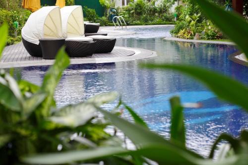 two lounge chairs sitting next to a swimming pool at Fraser Suites Hanoi in Hanoi