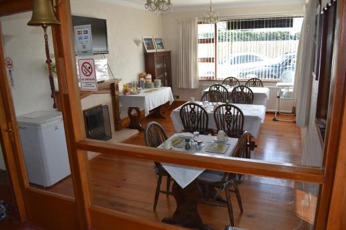 - une salle à manger avec une table, des chaises et un miroir dans l'établissement Brae-Mar B&B, à Portrush